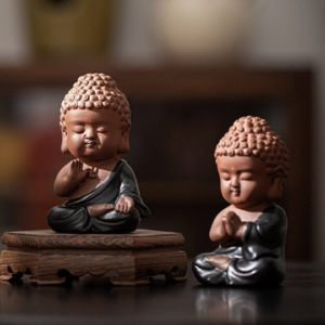 Handmade cute clay Buddha tea pet main product view on wooden table