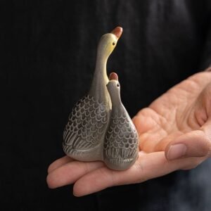 Hand holding parent-child goose color changing tea pet to show size and detail