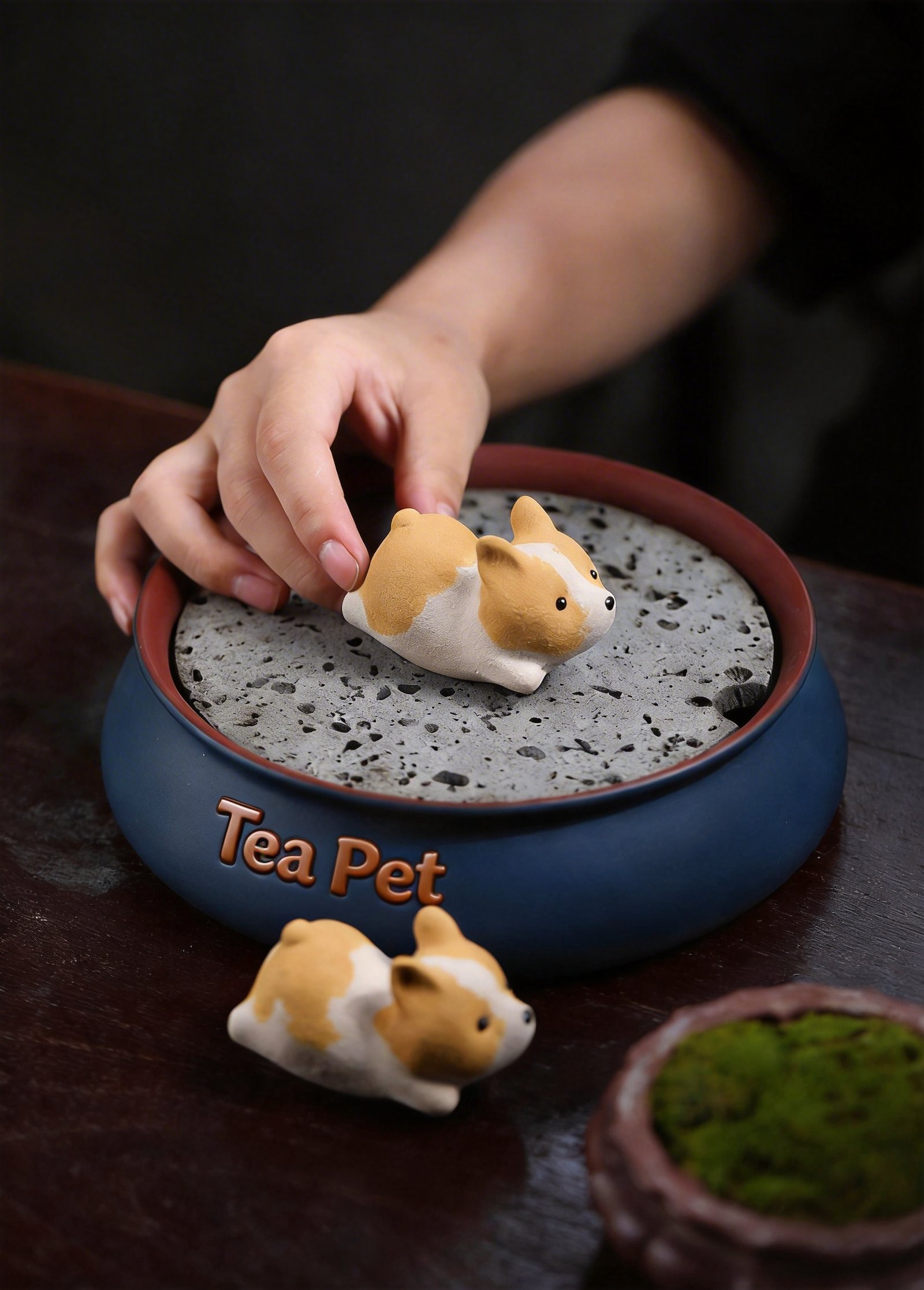 Hand picking up purple clay Corgi tea pet from a tea washing bowl