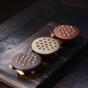 Handcrafted brown clay lotus seed pod tea pet on dark wooden tea tray, main view
