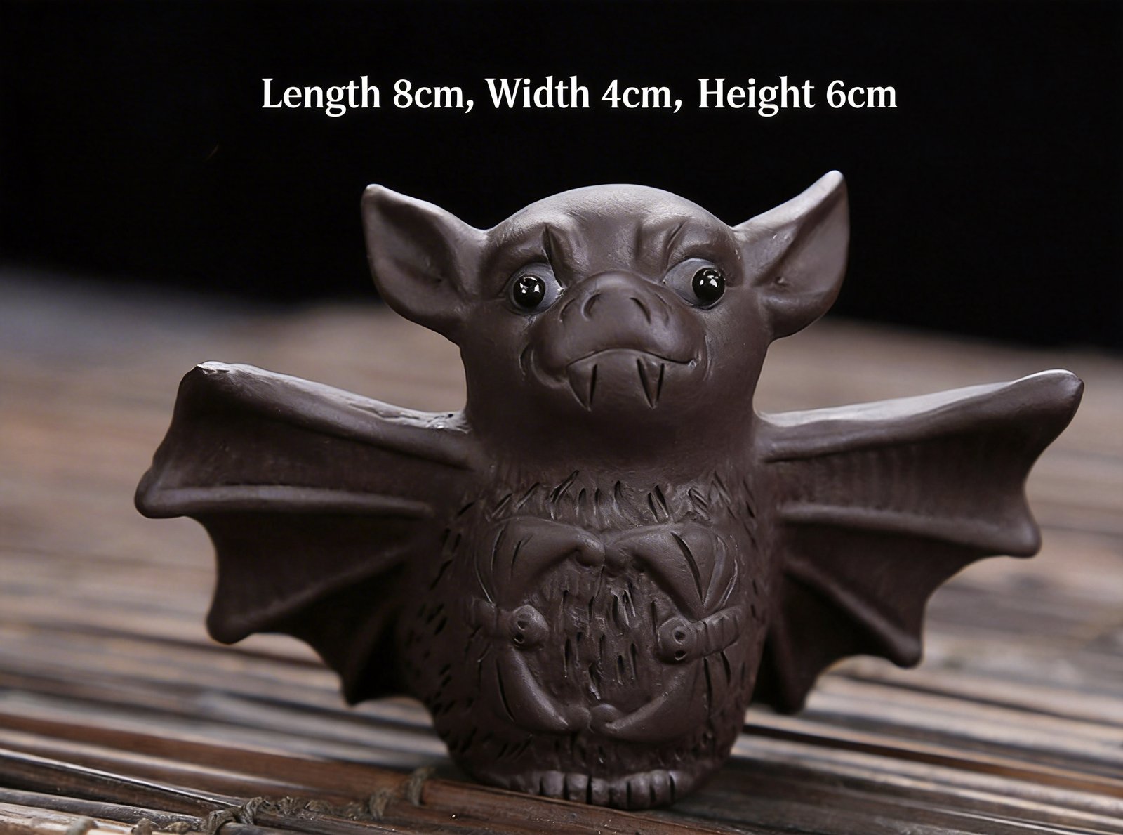 Dark brown lucky bat tea pet on bamboo mat with dimension labels