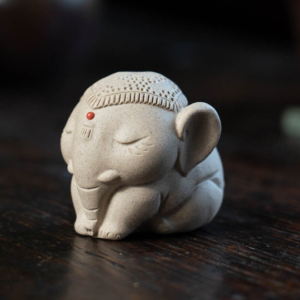 Handcrafted white purple clay elephant tea pet main view on dark wooden tea table