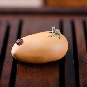 Handcrafted purple clay frog and beetle tea pet displayed on wooden tea tray