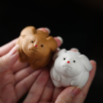 Main view of handmade yellow long-eared rabbit purple clay tea pet on wooden background