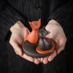 Hand holding Yin Yang fox purple clay tea pet full set