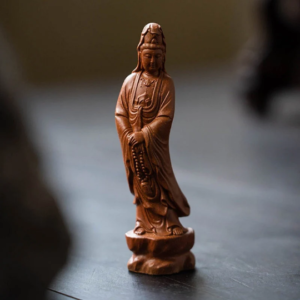 Main view of handcrafted Yixing purple clay Guanyin Bodhisattva tea pet on dark wooden tea table