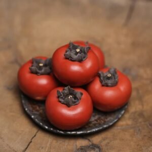Main view of Yixing purple clay persimmon tea pet with lifelike ripe red persimmon design