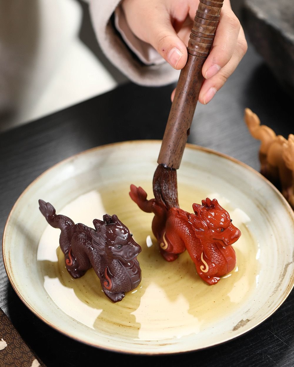 Brushing red zisha dragon tea pet with tea liquid