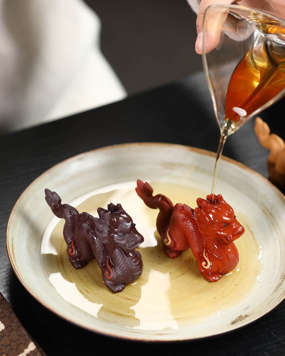Pouring tea over red zisha dragon tea pet during gongfu tea ritual