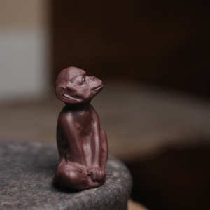 Handcrafted Yixing zisha brown monkey tea pet front view on stone tea tray