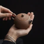 hand holding handmade 110ml mini clay gongfu tea pot