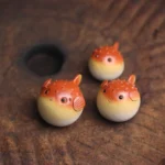 Full set of 3 cute orange puffer fish ceramic tea pets displayed on a Gongfu tea table