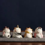 Full set of 4 cute Chinese imperial cat resin figurines displayed on a grey table