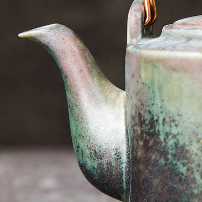 aged copper handle detail on vintage chinese ceramic teapot