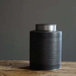 airtight metal tea jar with black textured body and silver lid