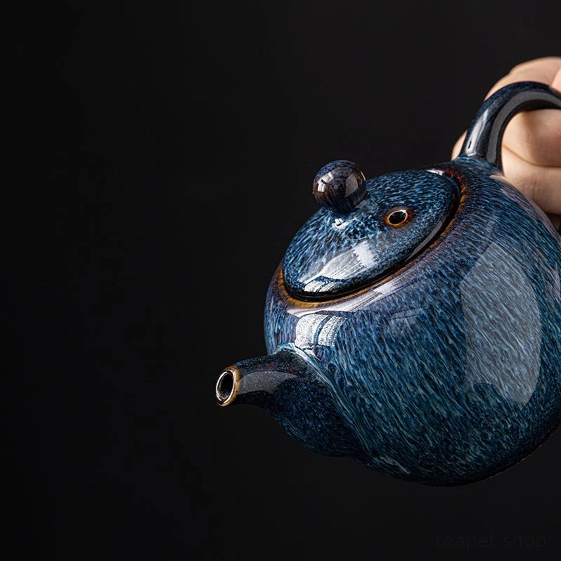 close up of the unique filament pulled glaze texture on blue teapot