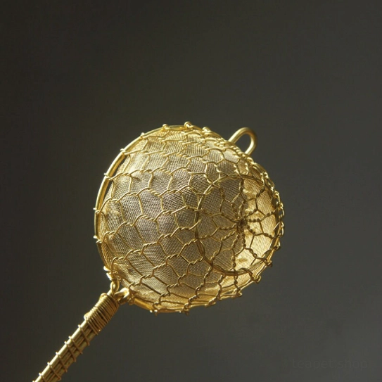 close up of wrapped ergonomic handle of brass tea strainer