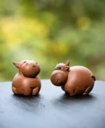 Handmade warm brown Yixing purple clay ox tea pet main view on black tea tray