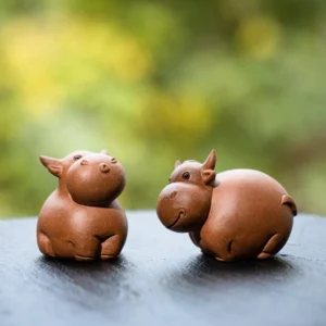 Handmade warm brown Yixing purple clay ox tea pet main view on black tea tray