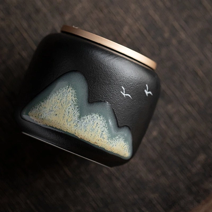 Detailed view of carved wave design on the metal lid of the tea jar