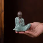 Main view of handcrafted celadon Ge Kiln crackle glaze Zen monk tea pet on wooden tea tray