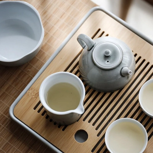 celadon ceramic teapot with lid lifted off to show opening