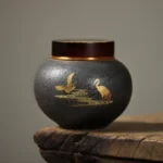 Full view of dark gray ceramic golden crane airtight tea jar