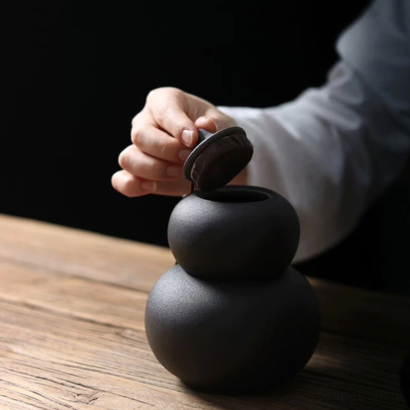 ceramic gourd tea jar with tasseled lid on the small canister