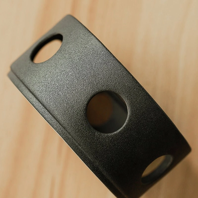 Side angle view of ceramic tea warmer stand with decorative cutouts