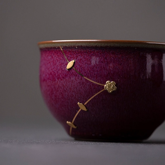 close up of gold kintsugi flower decoration on purple tea cup