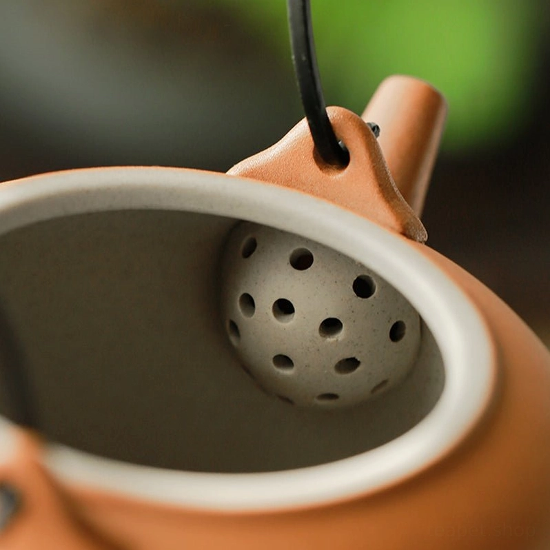 Close up of jute wrapped metal handle on ceramic mountain teapot