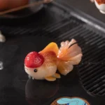Group display of two color changing goldfish tea pet designs on a Gongfu tea tray