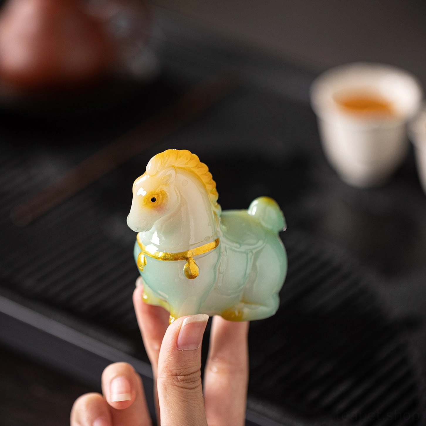 size comparison of tang horse tea pet held in hand
