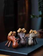 Handmade reddish brown donkey purple clay tea pet main view on black tea tray