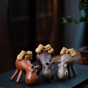 Handmade reddish brown donkey purple clay tea pet main view on black tea tray