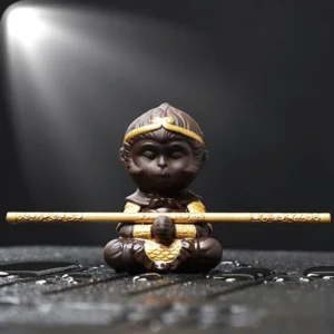 front view of color changing sun wukong purple clay tea pet with golden staff