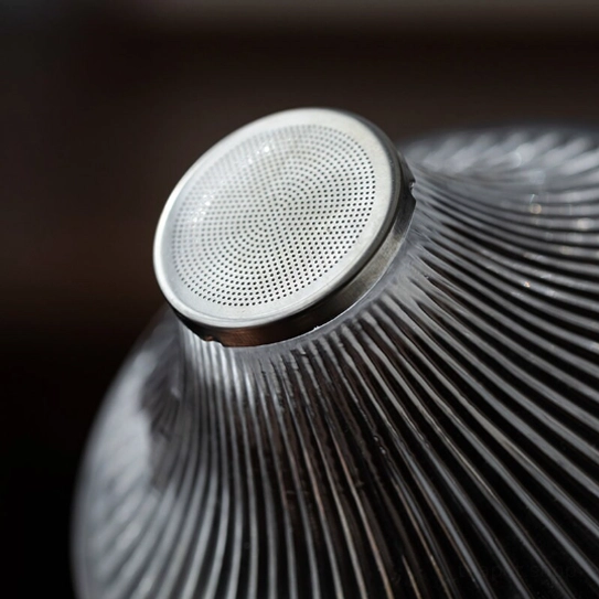 side view of striped body of glass loose leaf tea strainer with gold accents
