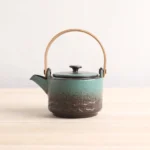 full view gradient blue-green ceramic teapot with wooden handle and metal infuser