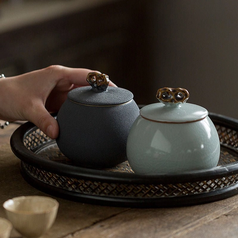 handcrafted green ceramic tea jar on wooden table