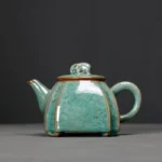 handcrafted green speckled ceramic teapot with elephant lid knob front view