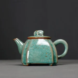handcrafted green speckled ceramic teapot with elephant lid knob front view