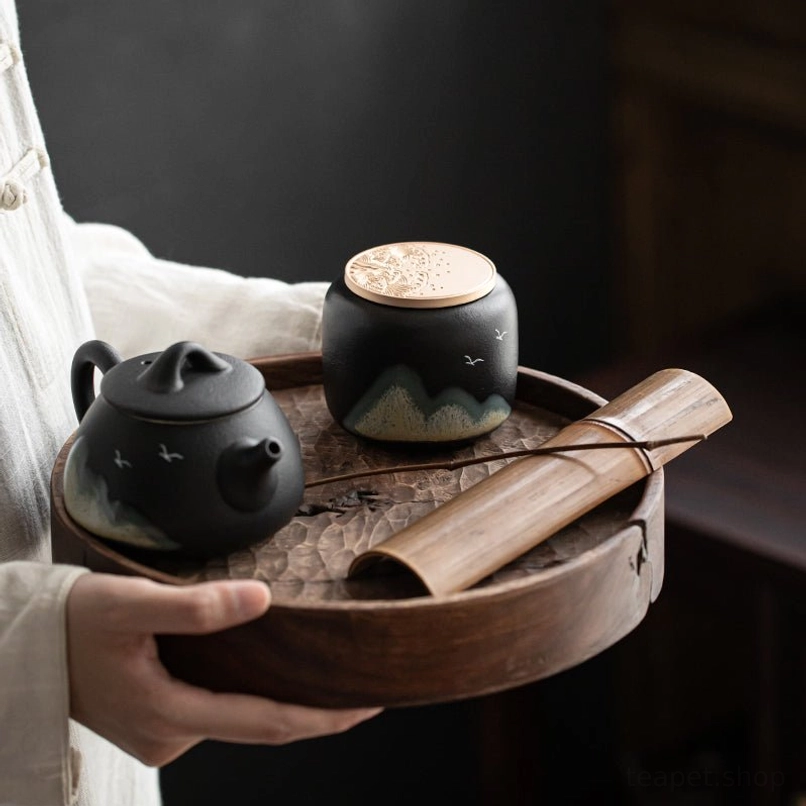 Close-up of hand-glazed mountain and bird landscape details on the tea jar