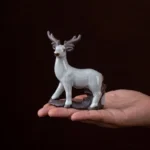Hand held handcrafted ceramic deer tea pet showing compact size