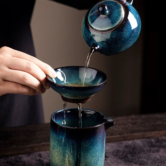 hand holding the jian ware tea strainer to show size and texture