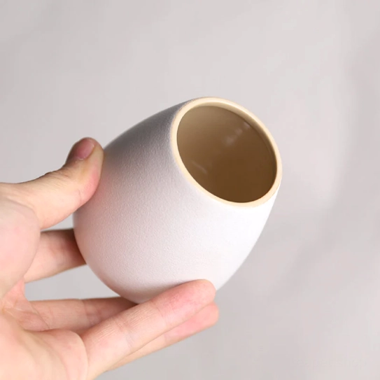 hand holding pear shaped ceramic tea jar showing comfortable grip