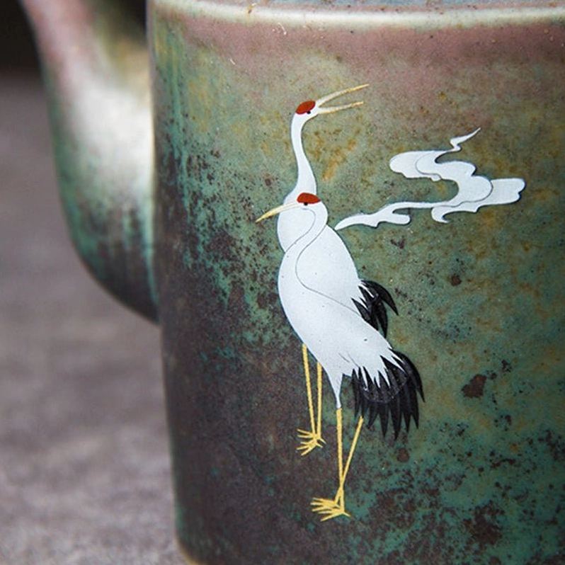 detailed view of hand painted crane and cloud pattern on vintage ceramic teapot