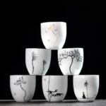 full set of hand painted zen porcelain tea cups on wooden background