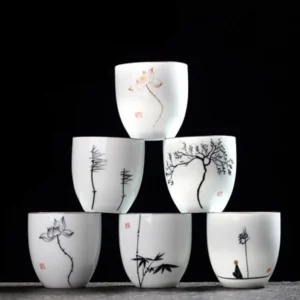 full set of hand painted zen porcelain tea cups on wooden background