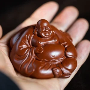 Handheld view of handcarved purple clay Maitreya Buddha tea pet