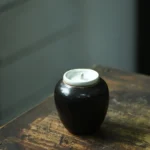 handcrafted black ceramic tea jar with white lid main view